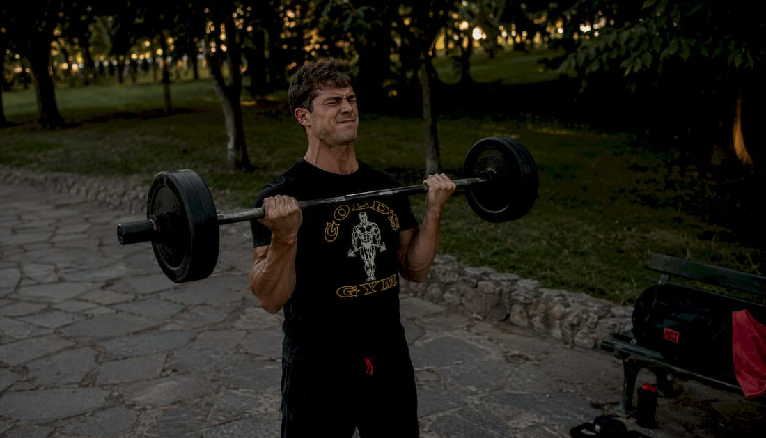 Man lifting weights wearing Pumping Iron t-shirt outdoors