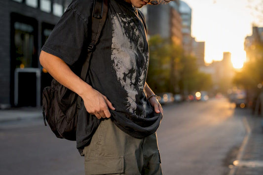Man adjusting streetwear tee on urban street