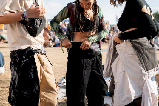 Young adults adjusting streetwear layers at festival