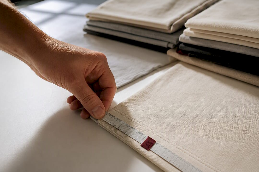 Hand measuring anonymous heavyweight cotton tee hem
